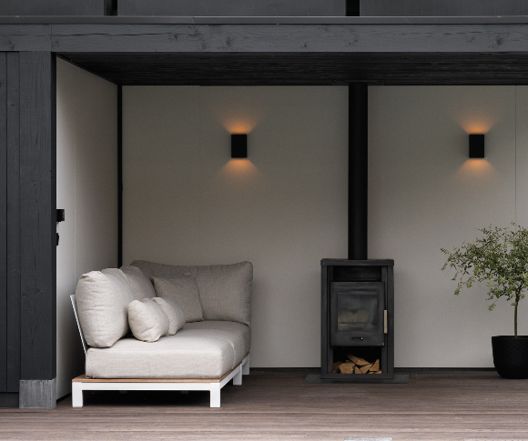 Hout haard in tuinkamer overkapping met beton stuc in de kleur grijs