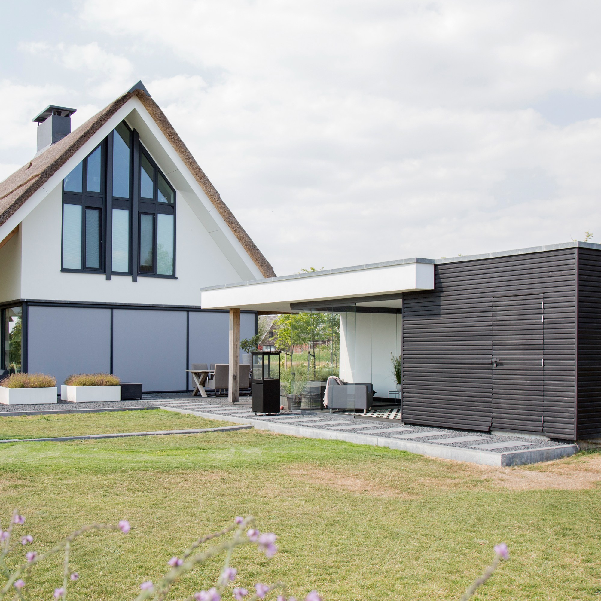 Moderne tuinkamer met wit en zwart naast een landelijk modern huis