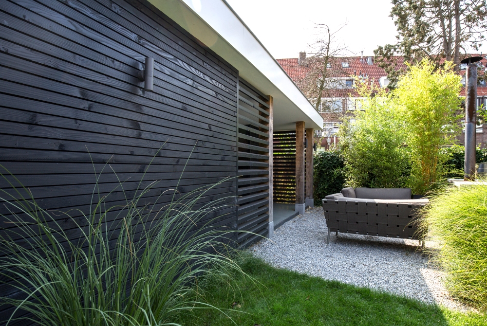 Moderne tuinkamer met een wit dak en zwarte douglas wanden met eikenhout